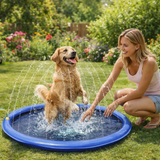 Une jeune femme souriante accroupie à côté de son chien Golden Retriever qui joue et saute au milieu des jets d'eau d'un tapis rafraîchissant bleu dans un jardin fleuri.