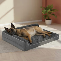 Berger belge Malinois allongé sur un lit orthopédique gris surélevé