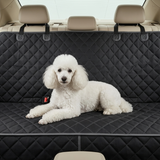 Couverture de siège arrière de voiture noire et matelassée pour chien, avec un petit chien blanc à poil frisé allongé confortablement sur la protection.
