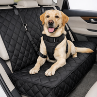 Un chien de race Golden Retriever ou Labrador beige, portant un harnais de sécurité noir, est sagement couché sur la housse de protection de siège arrière matelassée noire.