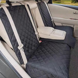 Housse de protection noire et matelassée pour chien sur une banquette arrière de voiture beige, illustrant l'ouverture zippée modulable qui permet de rabaisser l'accoudoir central de la voiture.
