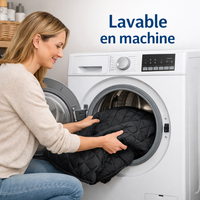 Une femme insère la couverture de siège auto noire et matelassée pour chien dans une machine à laver blanche, illustrant la mention « Lavable en machine »
